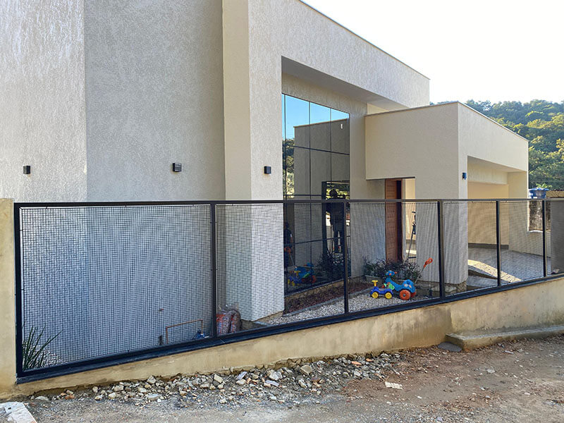 Cerca metálica preta com tela instalada em residência de alto padrão em Joinville
