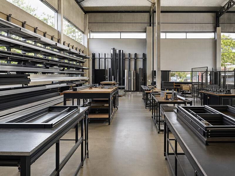 Interior da oficina de serralheria Metal Quality em Joinville com perfis metálicos, bancadas e estruturas de aço